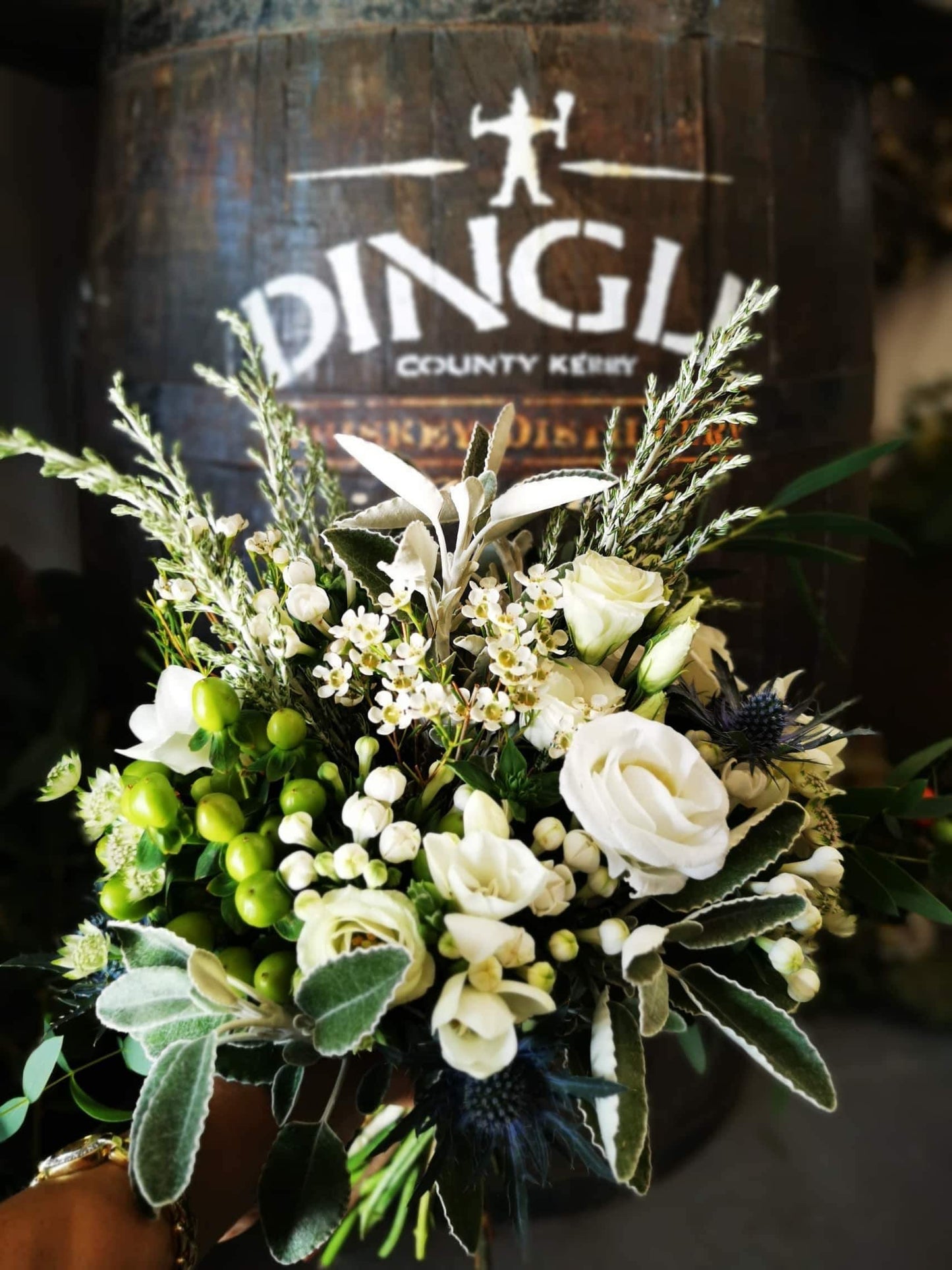 Hand-tied white bouquet featuring white flowers with soft petals and natural greenery, wrapped in kraft paper in Wisteria’s signature wild and elegant style.