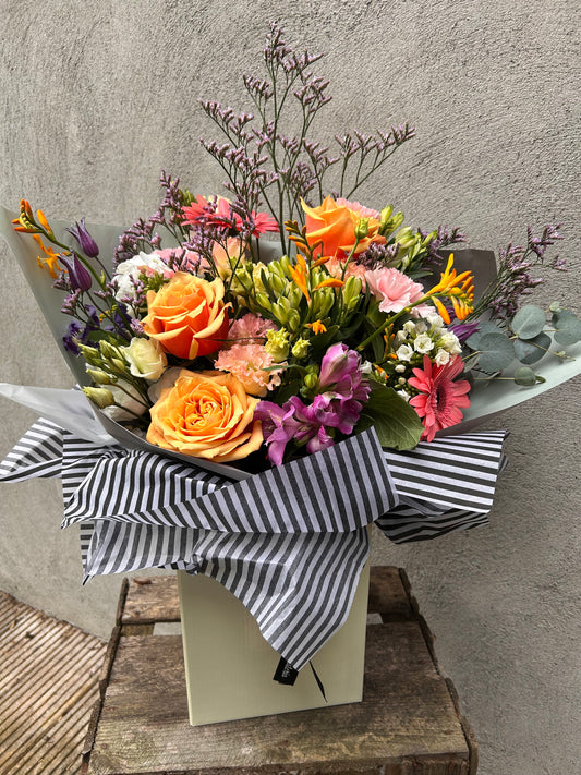 bouquet of flowers with a striped ribbon on a textured surface