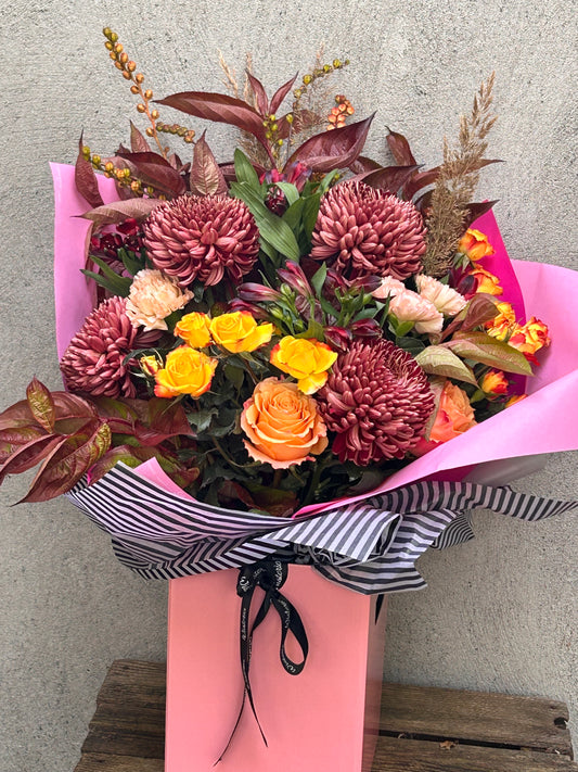 Handcrafted bouquet 'All is Orange' with seasonal blooms in rich colors and textures for a unique gift.